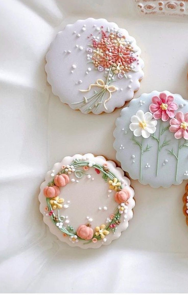 four decorated cookies sitting on top of a white table