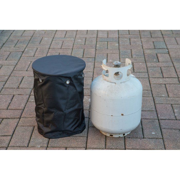 two gas tanks sitting next to each other on a brick floored area with a black bag