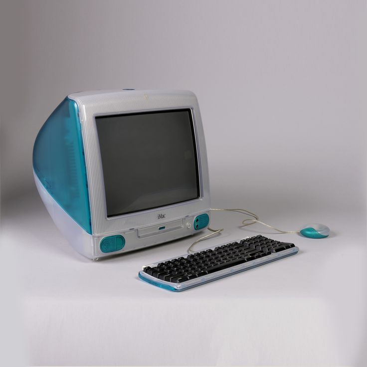 an old computer sitting on top of a white table next to a keyboard and mouse