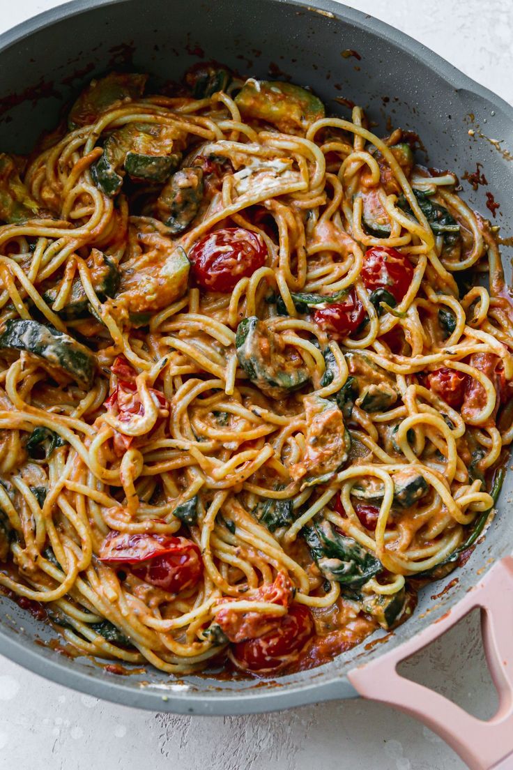 a skillet filled with pasta and vegetables