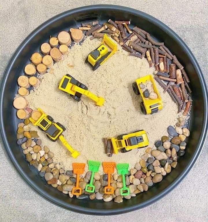 a bowl filled with toys and sand on top of a table