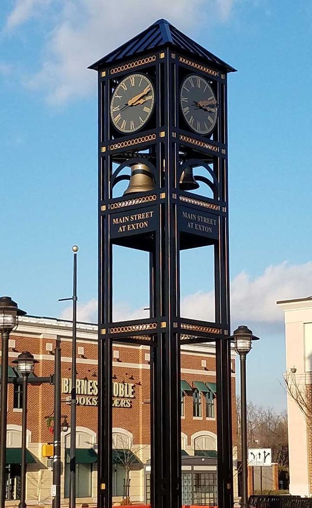 a tall clock tower sitting on the side of a road