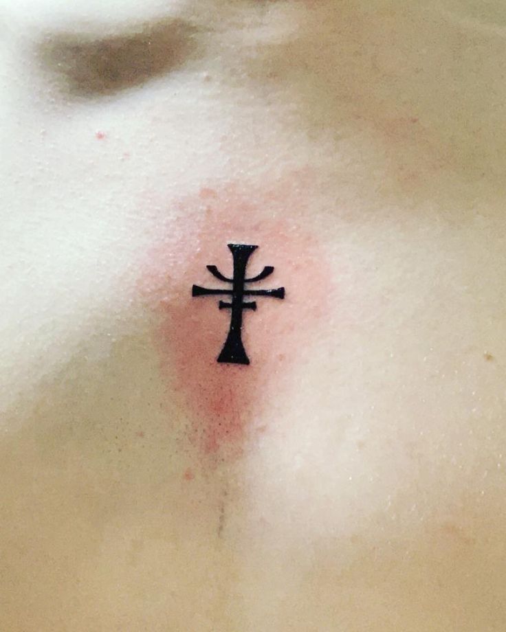 a cross tattoo on the chest