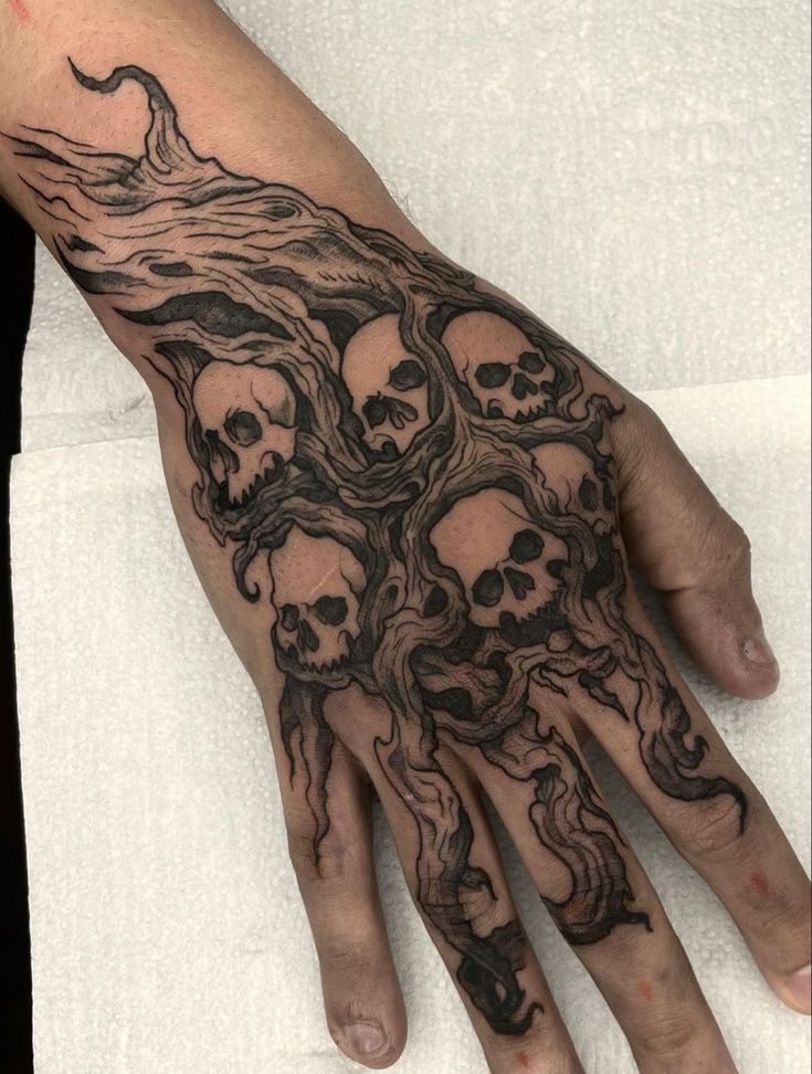 a man's hand with many skulls on it