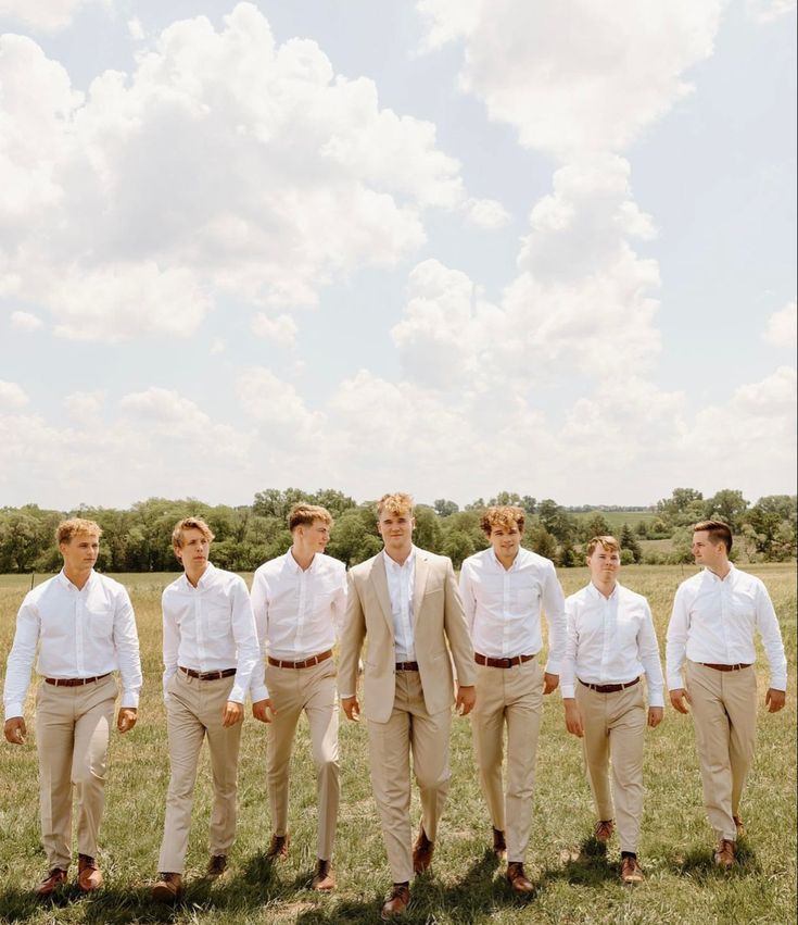 a group of men standing next to each other in a field