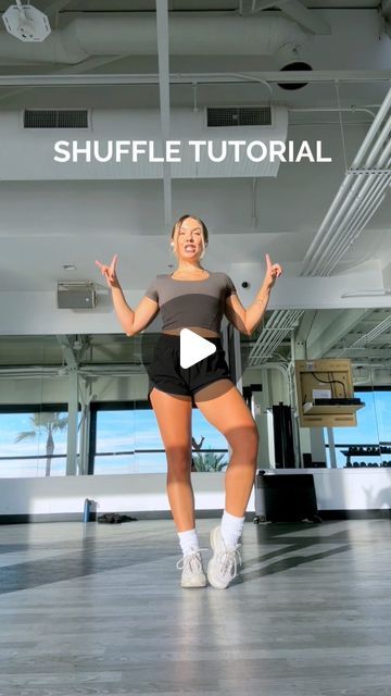 a woman in short shorts is dancing with her hands out and the words shuffle tutor above her head