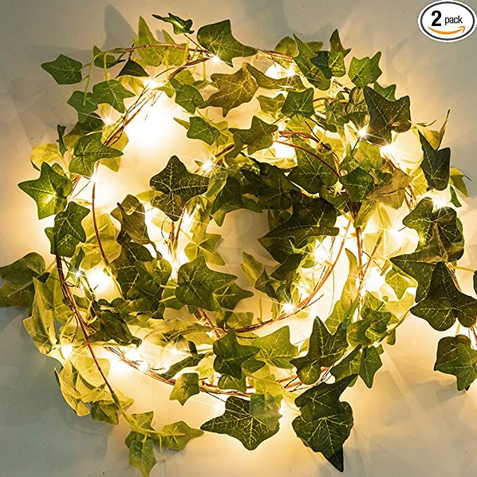 a lighted wreath with ivy leaves on it