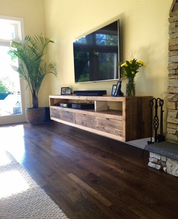 a flat screen tv sitting on top of a wooden entertainment center in a living room