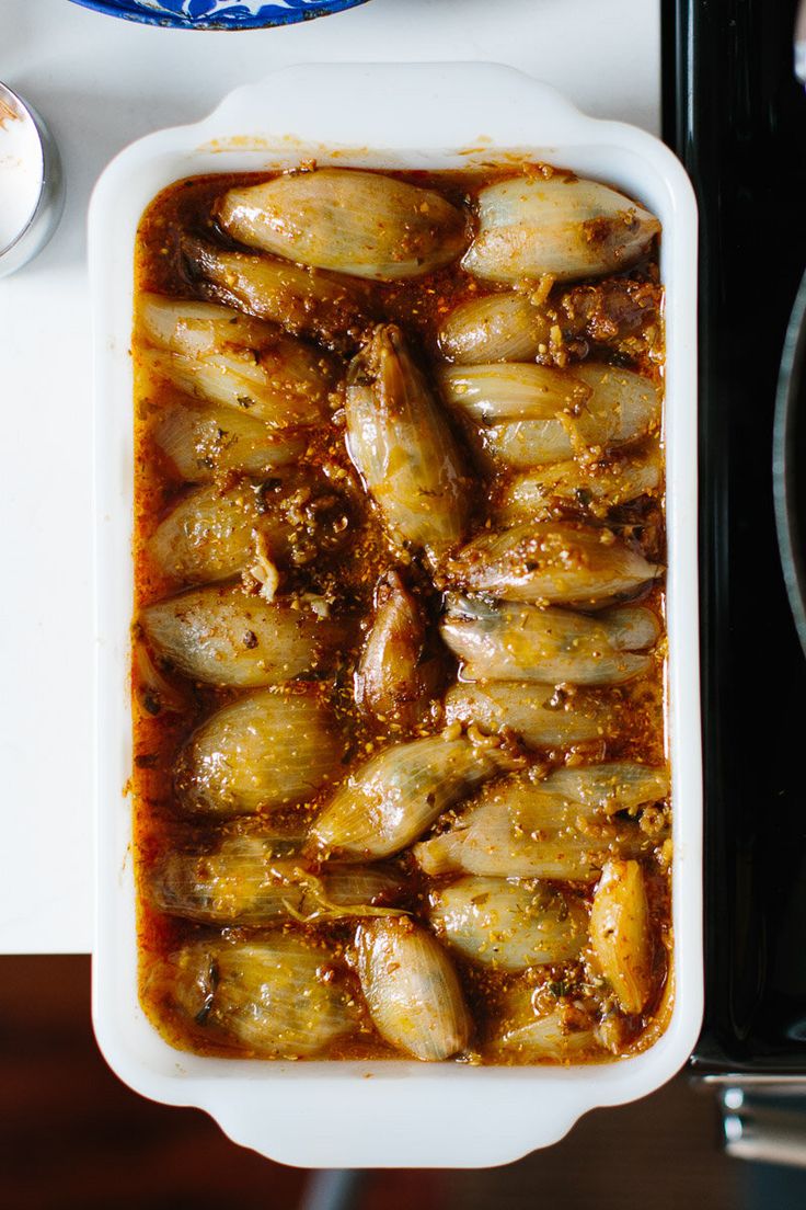 a casserole dish filled with food sitting on top of a table next to a plate