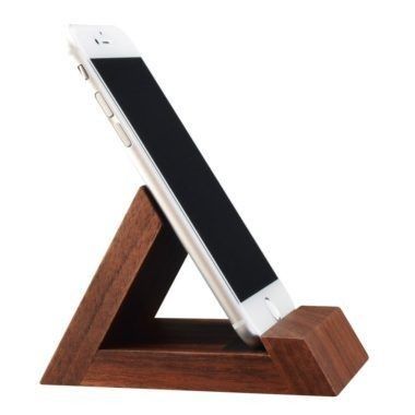 an iphone is sitting on top of a wooden stand with a white phone in it