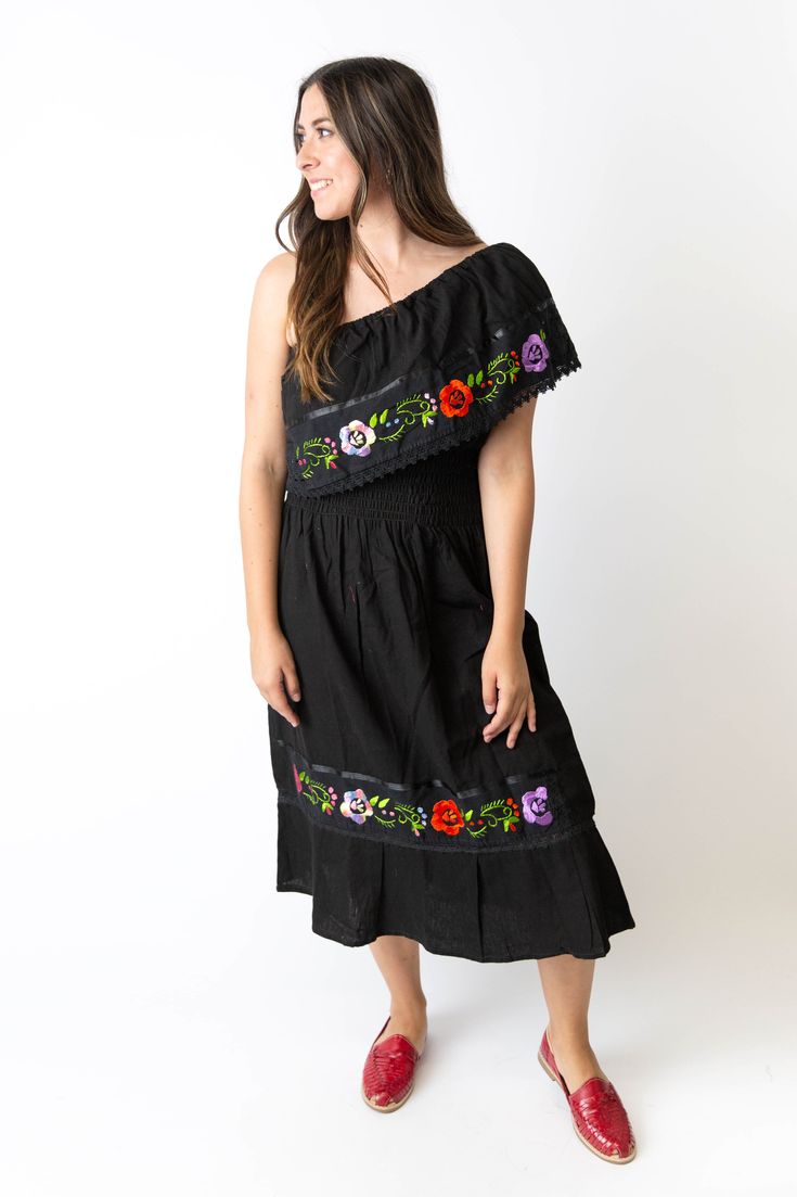 Mexican Pueblo One Shoulder Dress - Black  Mexican Pueblo One Shoulder Dresses are ideal for any occasion and will definitely make a fashion statement at the next Fiesta!  Please note that each dress is individually embroidered so the embroidery design will vary from the one pictured. You will receive the dress color selected.  This is a ONE SIZE FITS Small through Large  Length: Approx: 38" inches Black Folk Embroidered Summer Dress, Traditional Black Spring Dresses, Black Peasant Dress For Summer, Black Peasant Dresses, Black Cotton Folk Embroidered Dress, Black Cotton Folk Dress, Black Peasant Dress For Spring, Traditional Black Dress With Embroidered Hem, Black Folk Style Cotton Dress