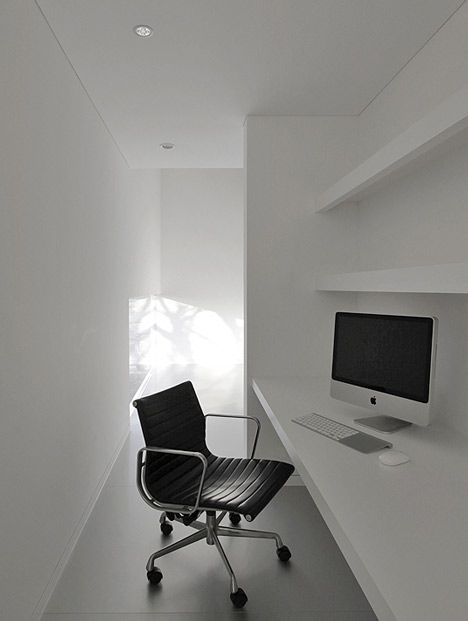 a chair sitting in front of a computer monitor on top of a white shelf next to a desk