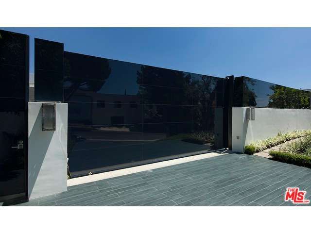 a black and white photo of a house with large glass doors on the side of it