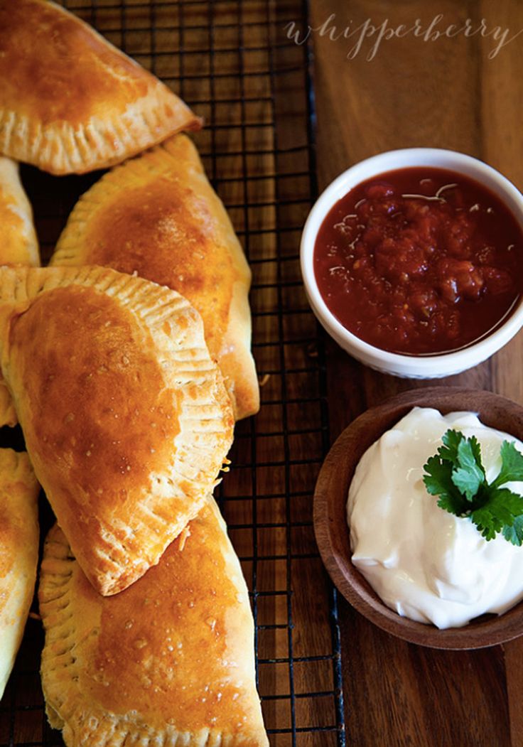 baked pastries on a cooling rack with dip and sour cream