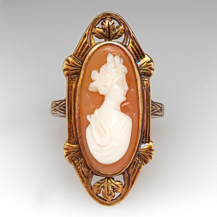 This lovely antique shell cameo cocktail ring has a nice low profile design and is crafted of 14k yellow gold. There are well preserved intricate details on the ring face and band and it has a gentle worn patina that further accentuates the designs. The ring is currently size 4.75 and polishing is not recommended, it is great as is. Vintage Carved Rings For Formal Occasions, Vintage Oval Carved Engraved Ring, Victorian Style Oval Engraved Ring, Vintage Filigree Ring With Intaglio For Formal Occasions, Vintage Filigree Intaglio Ring For Formal Occasions, Vintage Cameo Engraved Ring For Formal Occasions, Vintage Carved Rings For Formal Events, Victorian Oval Engraved Carved Ring, Antique Oval Filigree Ring