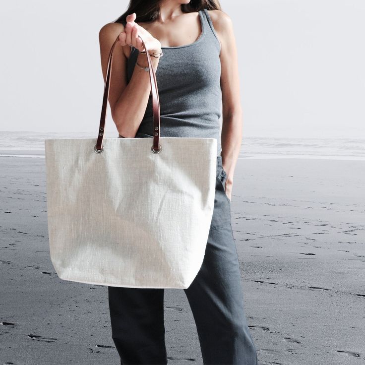 The perfect linen tote bag is an essential Summer accessory.  A great everyday bag that is timeless and modern.  Classic, textured linen is lightweight yet durable. and the neutral oatmeal color goes with just about anything.   Go ahead and stuff this bag with beach towels, books and laptops, it can handle it.  Roomy interior with easily accessible slip pockets and a large zipper pocket.   Will easily become your go-to bag all year long. Details: 14in H x 5in D x 17in W at top, 12in W at bottom Versatile Beige Tote Beach Bag, Everyday Lightweight Natural Bags, Versatile Everyday Beach Bag In Natural Color, Eco-friendly Summer Bag With Canvas Lining, Chic Summer Bag With Canvas Lining, Natural Linen Shoulder Bag For Everyday Use, Chic Summer Bags With Canvas Lining, Neutral Shoulder Bag With Rolled Handles For Travel, Everyday Natural Linen Bags