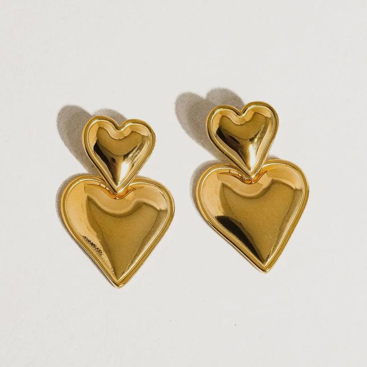 These layered hear earrings make heart earrings modern. This pairing of gold drop earrings features a simple stud connected to an elegant gold heart drop. We love this style for date night, girls' night, or really any night, as a matter of fact. 18k gold plated stainless steel Measurement (L x W inch): 1.2 x 0.8 Post back closure Tarnish free Style For Date, Jumpsuit Jacket, Cardigan Sweater Dress, Plus Size Shopping, Modern Earrings, Gold Drop Earrings, Gold Heart, Heart Of Gold, Heart Earrings