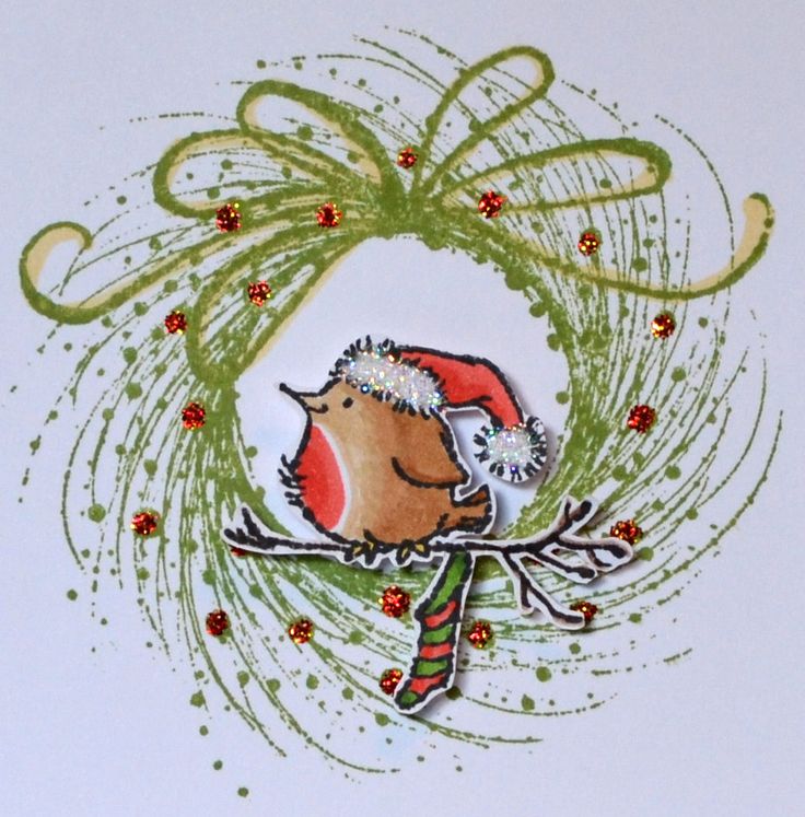 a handmade christmas card with a bird in a santa's hat on a branch