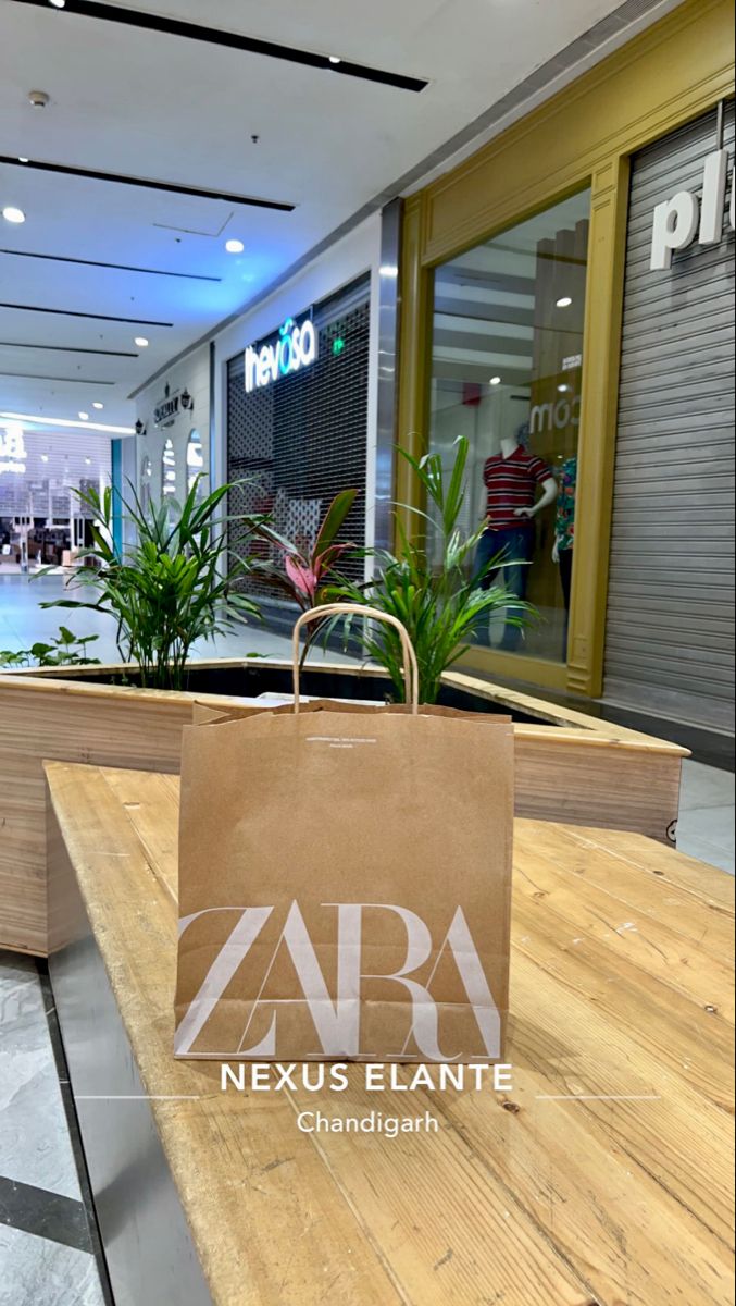 a brown paper bag sitting on top of a wooden table in front of a store