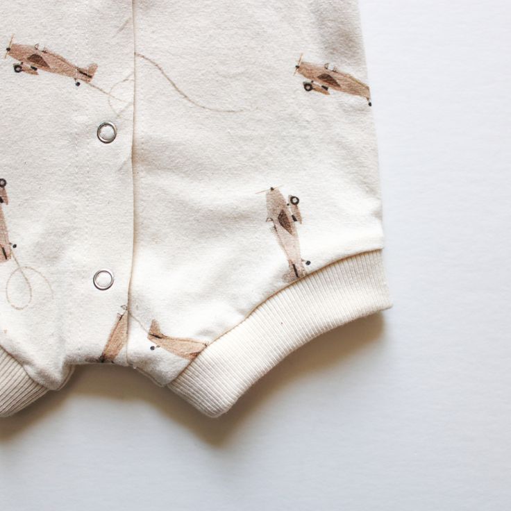 This little boy's romper is the perfect way to keep your child cool, comfortable, and stylish all summer long. The soft organic knit fabric will feel good against their skin as they play, and the snaps up the front make it easy to get in and out of. It also features a cute airplane design that will go with any outfit! Available in size NB- 2T CARE INSTRUCTIONS: Machine wash cold Gentle Cycle Tumble dry low or hang dry Warm iron if needed SHIPMENT & DELIVERY Orders will be ready for delivery with Cotton Bubble Romper For Playwear, Casual Cartoon Print Jumpsuits And Rompers For Playtime, Cotton Cartoon Print Jumpsuits And Rompers For Playwear, Cotton Jumpsuits And Rompers With Cartoon Print For Playwear, Cotton Playwear Jumpsuits And Rompers With Cartoon Print, Unisex Casual Short Sleeve Bodysuit For Playwear, Casual Short Sleeve Bodysuit For Playwear, Casual Cotton Bubble Romper With Short Sleeves, Casual Short Sleeve Bodysuit For Playtime