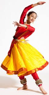 a woman in a red top and yellow skirt is doing a dance pose with her arms out