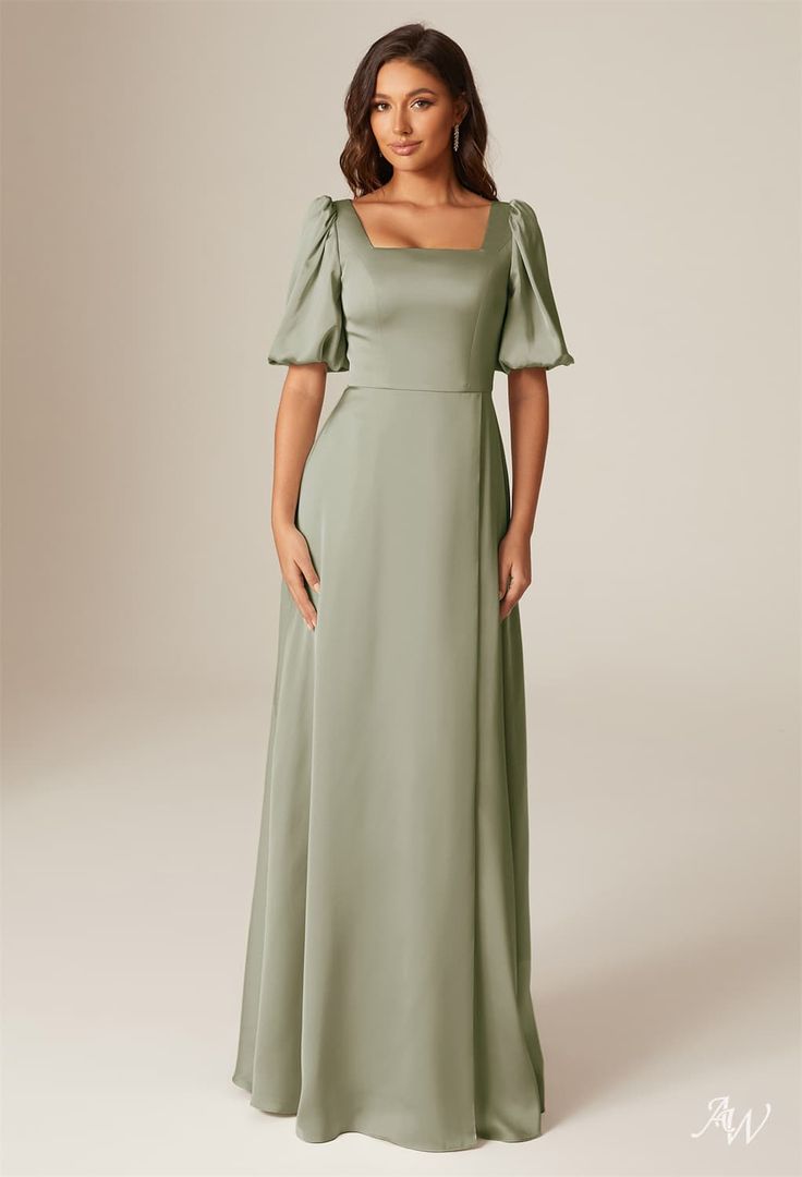 a woman in a long green dress with ruffle sleeves on the shoulders and shoulder