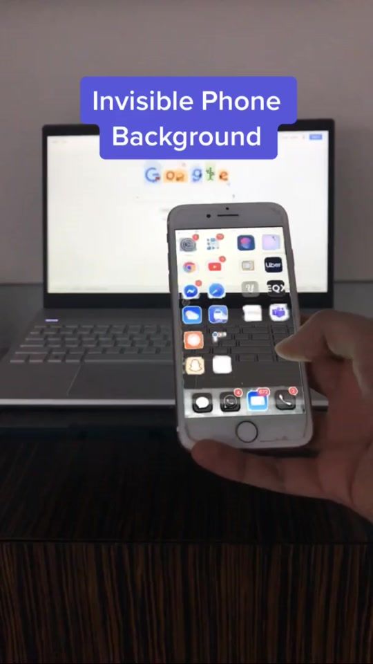 a person holding an iphone in front of a laptop with the text invisible phone background