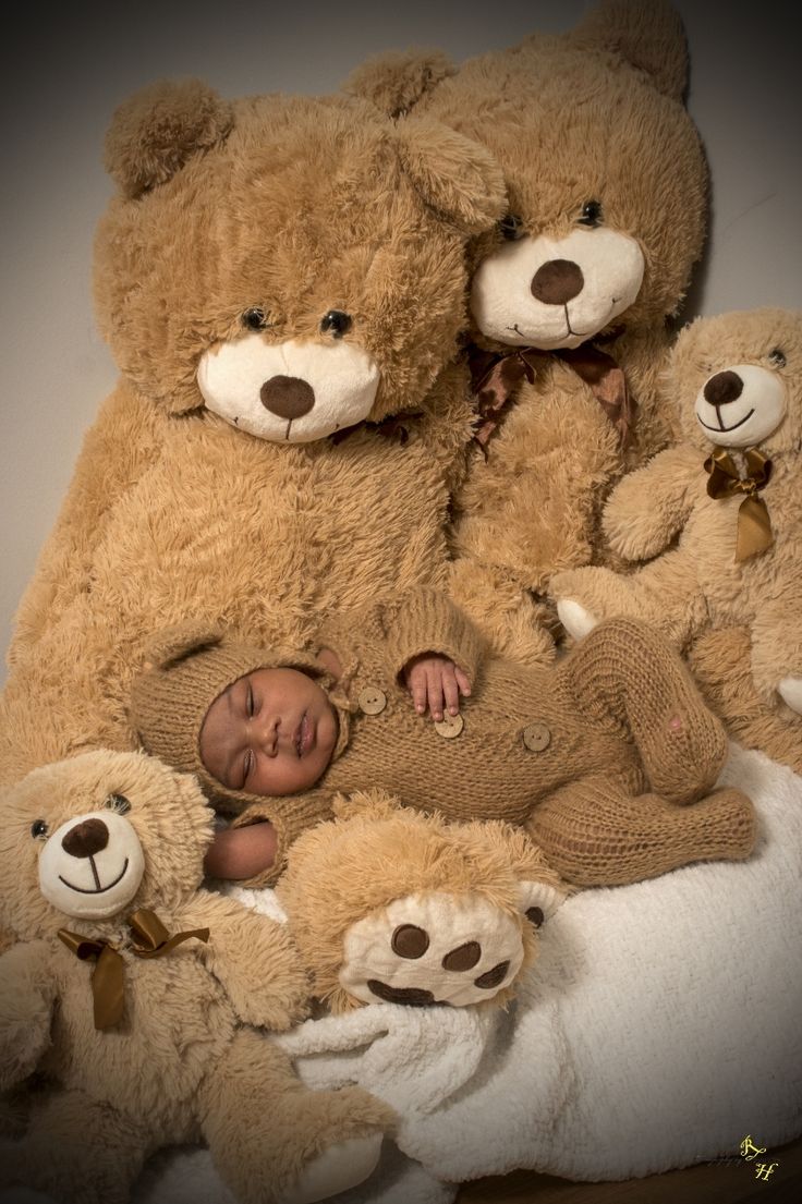 a baby is surrounded by teddy bears on a blanket