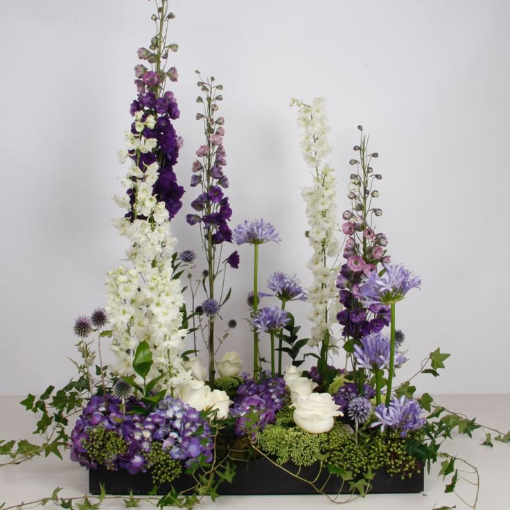 an arrangement of purple and white flowers on display