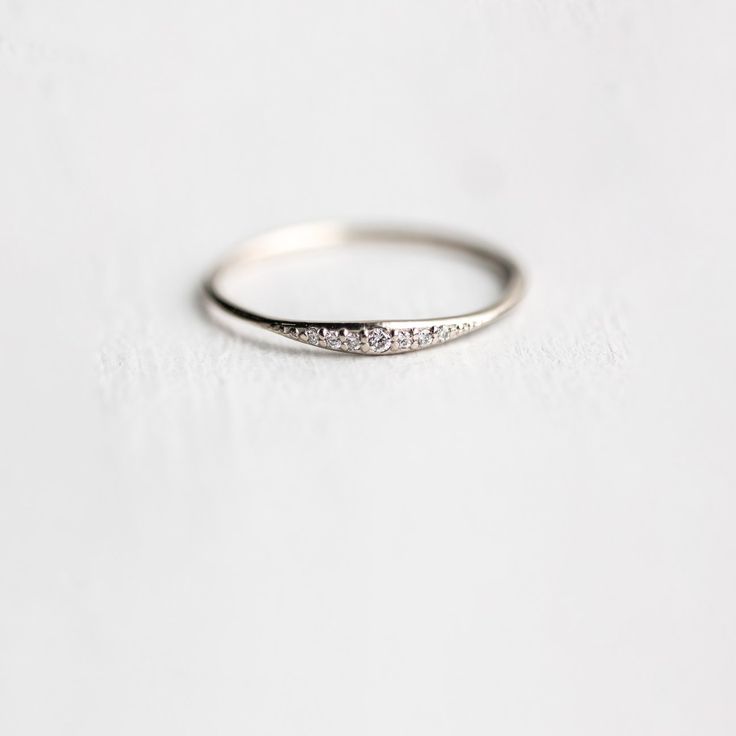 a white gold wedding band with five diamonds on the side, set in 18k white gold