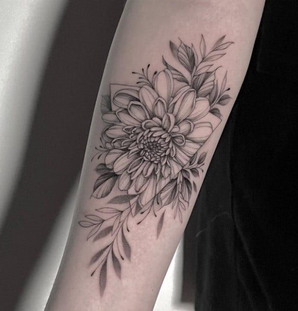 a black and white flower tattoo on the arm