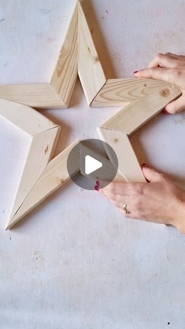 two hands are working on some wooden stars