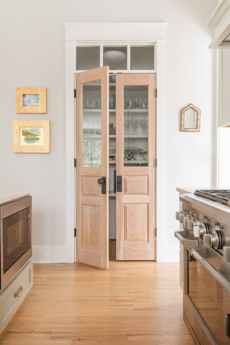 a kitchen with wooden floors and white walls