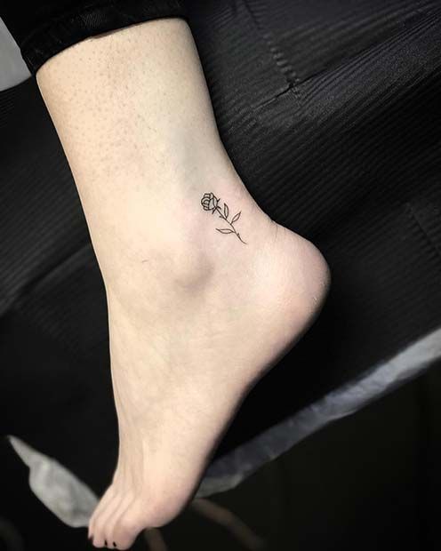 a woman's foot with a small flower tattoo on the left side of her ankle