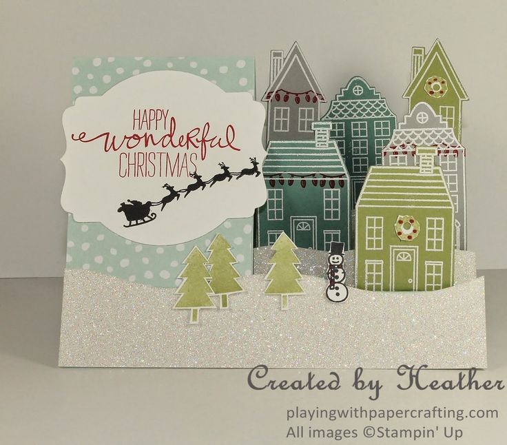 a handmade christmas card with santa's sleigh flying over the town