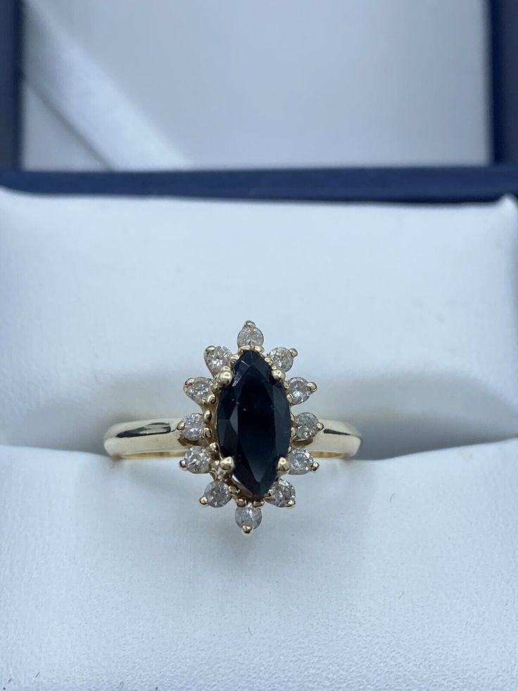 an engagement ring with a large blue stone surrounded by small white diamonds in a box