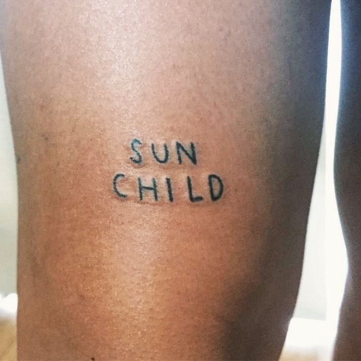 a woman's leg with the words sun child written on it