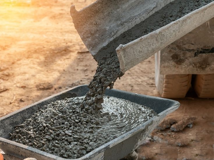 cement being poured into a bucket on the ground