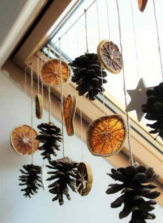 pine cones hanging from the side of a window sill with other decorations on it