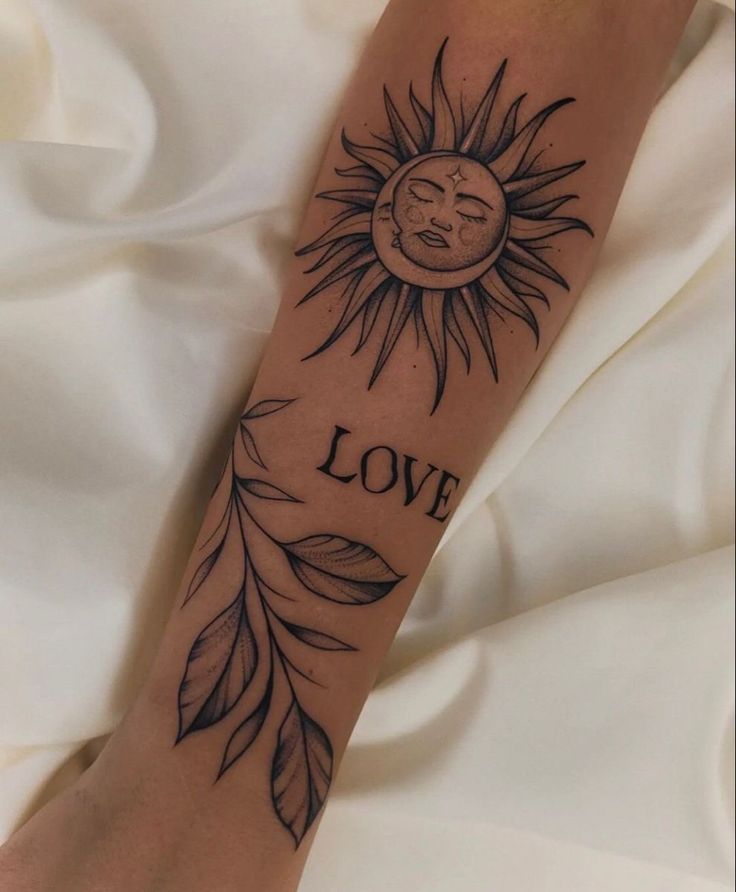 a person with a tattoo on their arm that reads love and has a sun in the middle