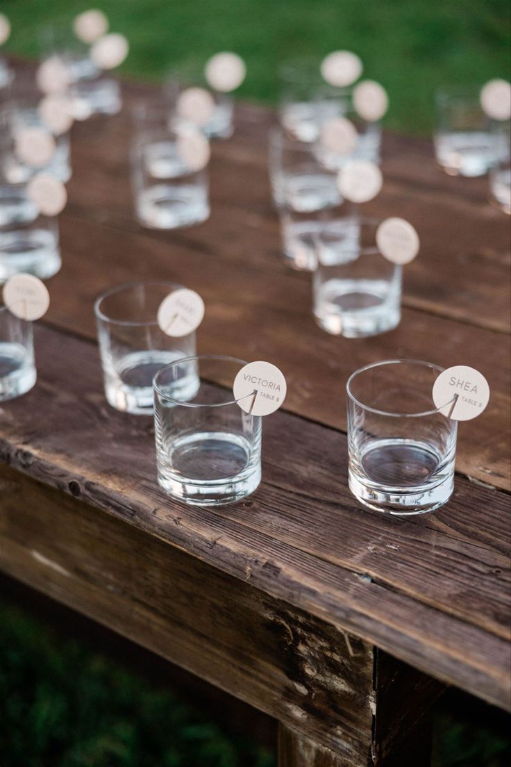 several shot glasses are lined up on a wooden table with labels that read, i do not know what they are