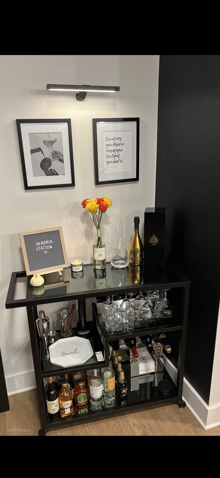 a bar cart with liquor bottles and glasses on it