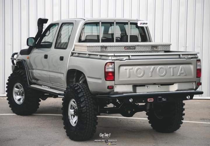 a silver toyota truck parked in front of a building