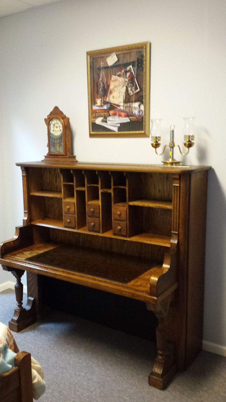 an old piano in a room with a painting on the wall