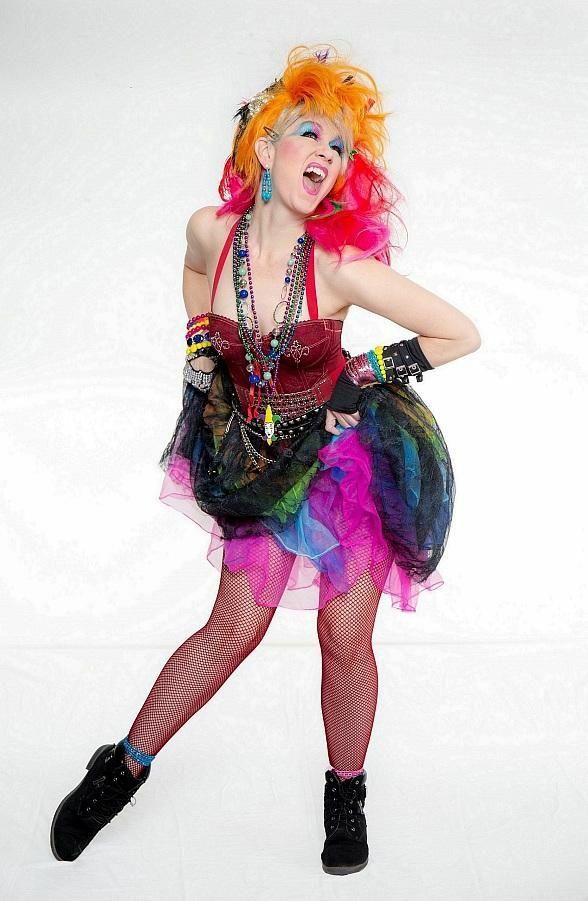 a woman dressed up as a clown posing for a photo in front of a white background