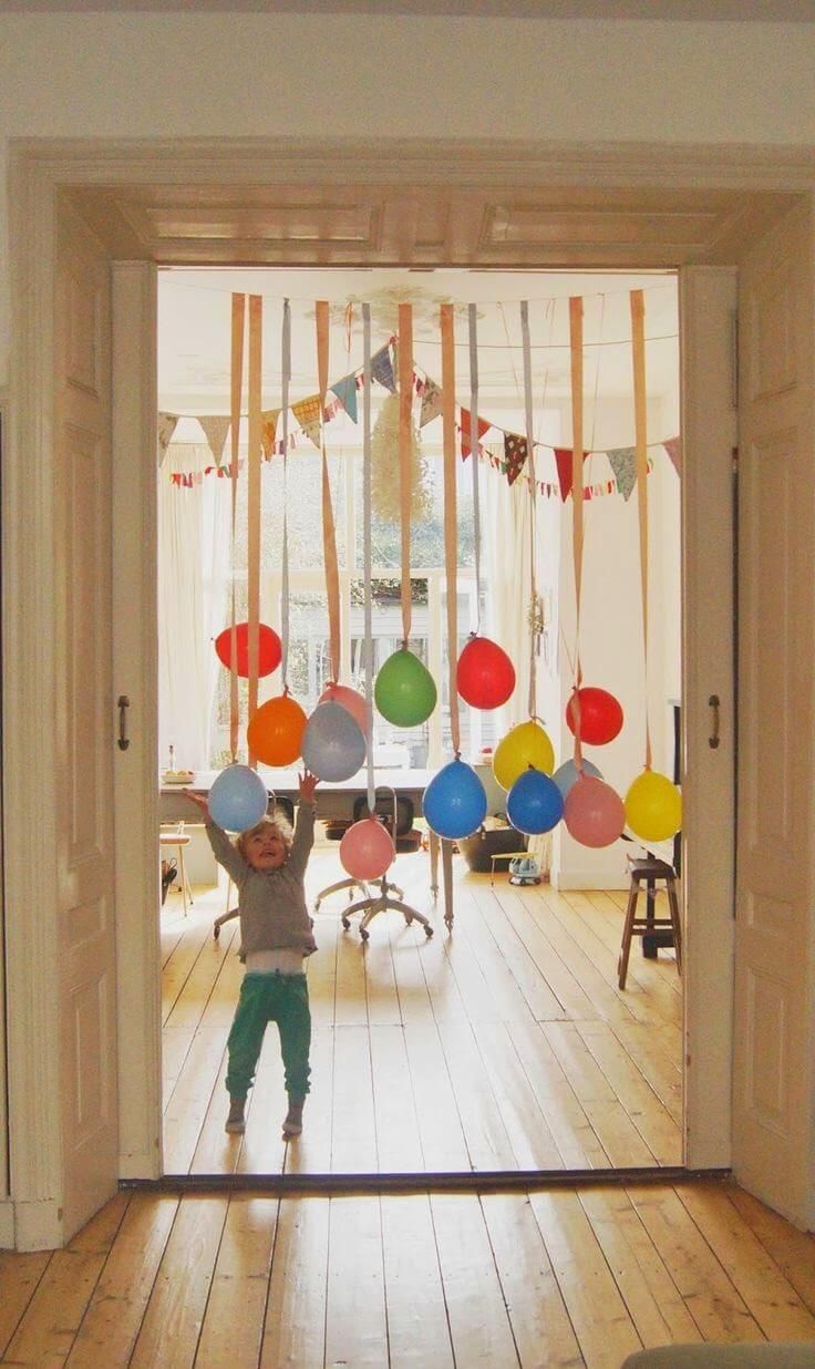 a child is standing in front of a birthday party door