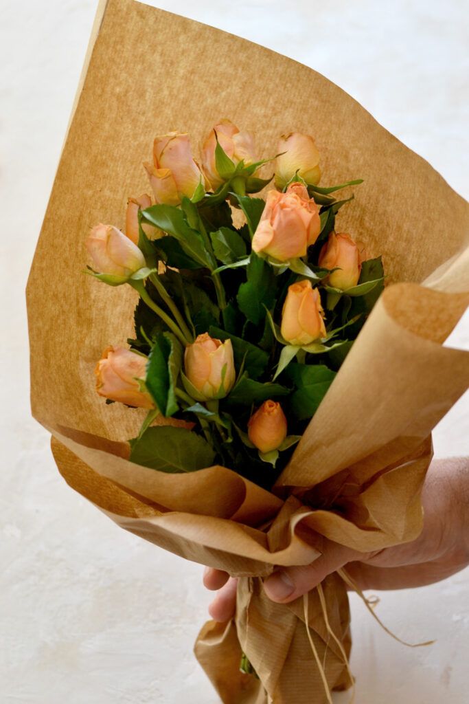 a person holding a bouquet of flowers in their hand and wrapping it around the edges