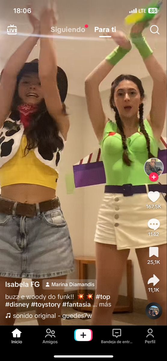 two young women are dancing together in the living room, one is holding her hands up