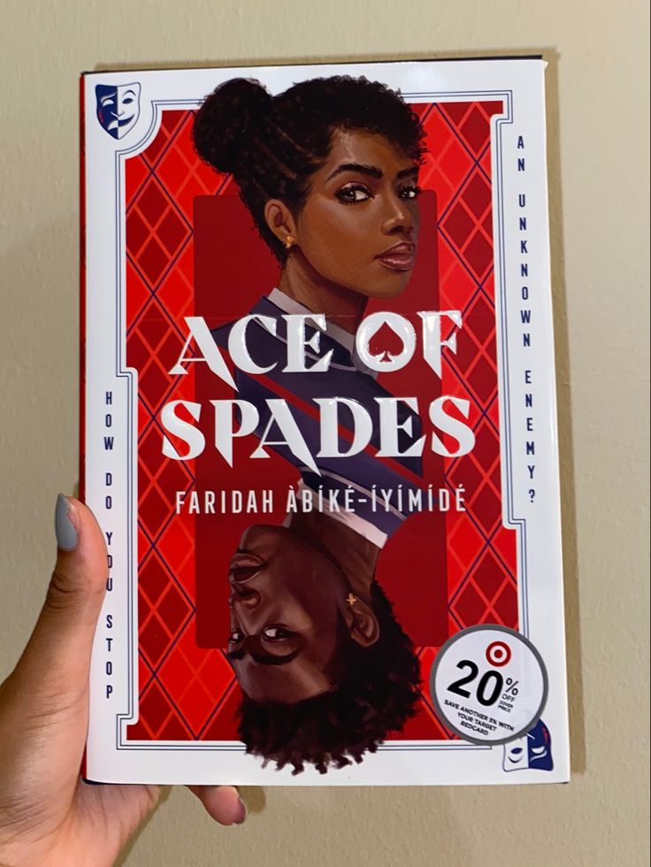 a person holding up a book about ace of spades