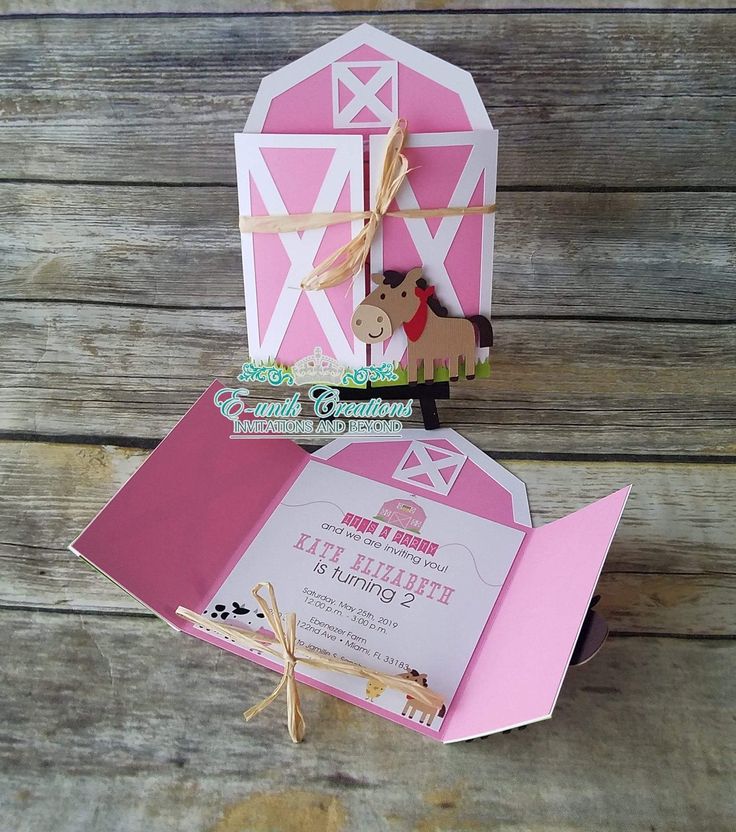 an open pink and white box with a horse on it's side, sitting on top of a wooden table